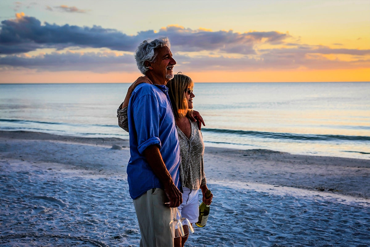 Elderly couple on florida beach looking into the sunset