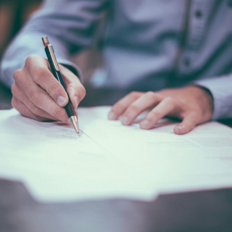 A person reviewing and signing insurance paperwork, representing the process of selecting the best family health insurance plans in Florida.