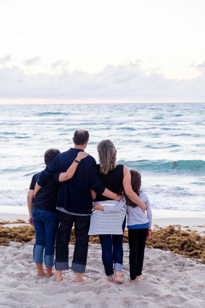A family of five standing together on a Florida beach, symbolizing comprehensive health insurance solutions designed to protect large families across the state.