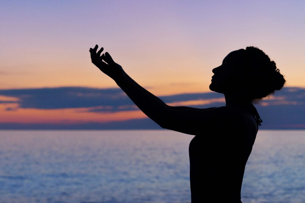 Woman enjoying a sunset by the water
