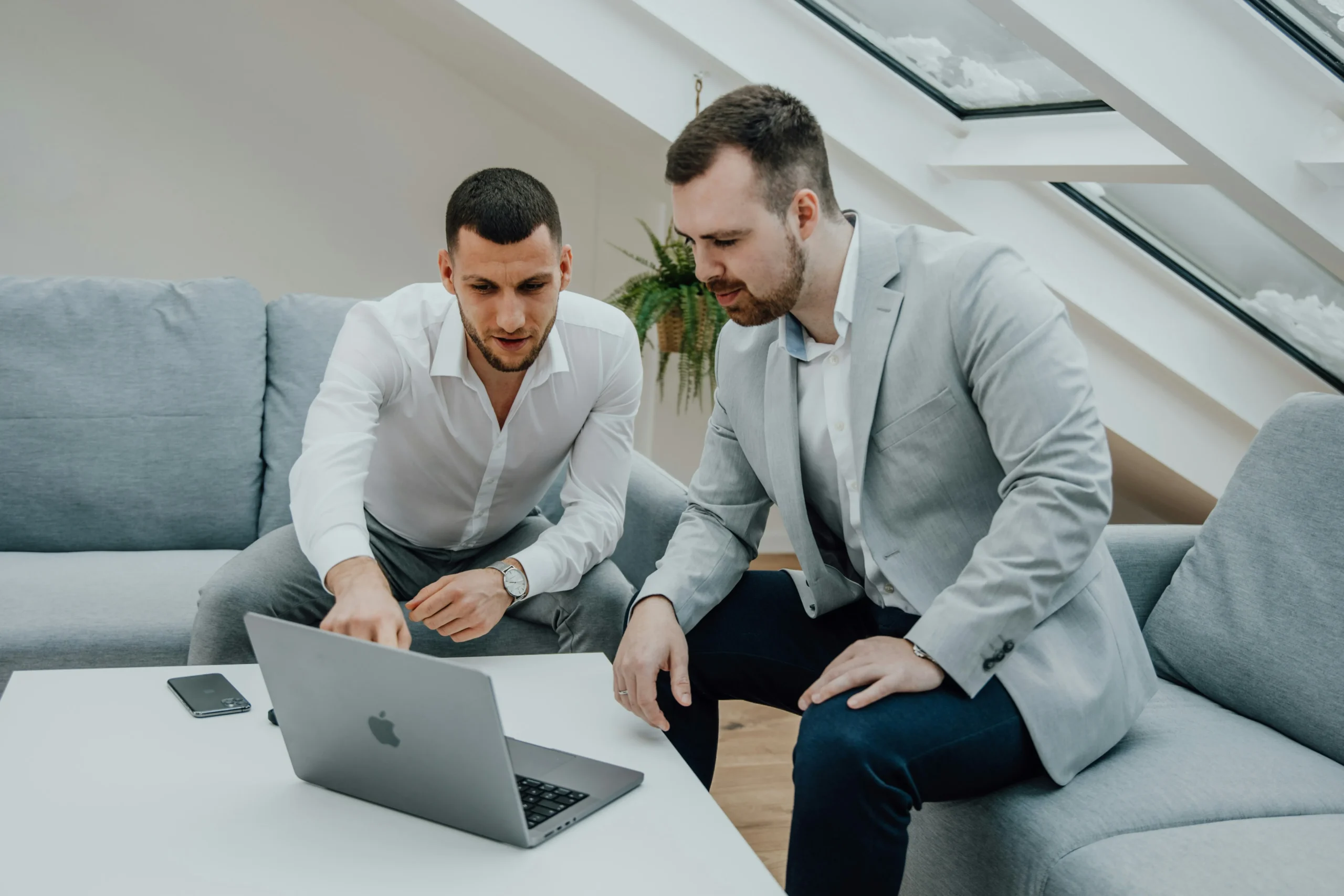 Two men in business attire discussing health insurance options on a laptop, emphasizing guidance and decision-making for Florida families.