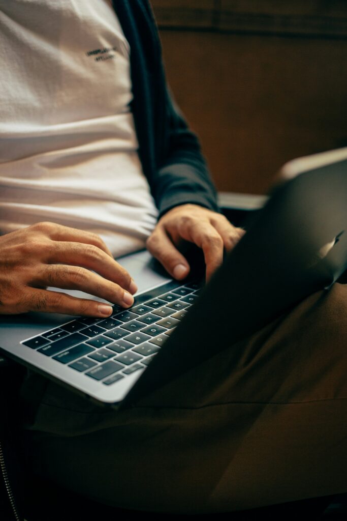 Person typing on a laptop, emphasizing technology's role in accessing health insurance information and understanding pre-existing condition coverage under the Affordable Care Act.