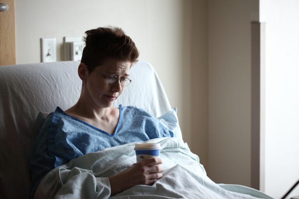 A patient resting in a hospital bed, representing the role of ancillary health insurance products like hospital indemnity and critical illness coverage in Florida.