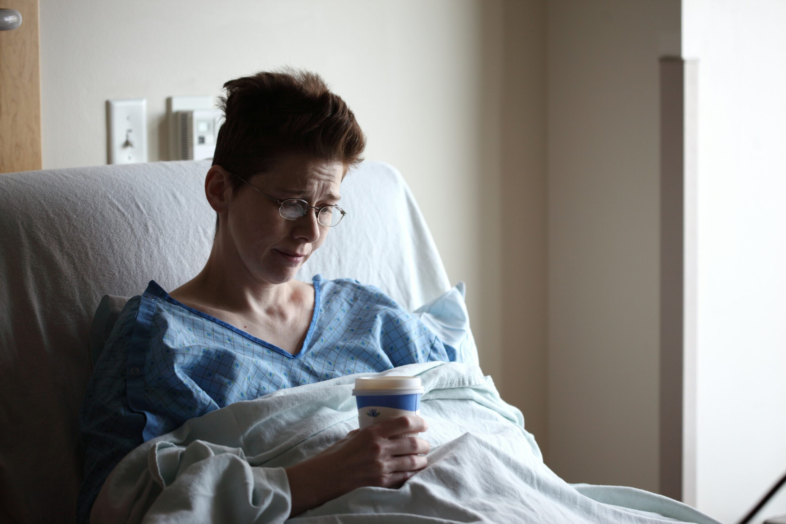 A patient resting in a hospital bed, representing the role of ancillary health insurance products like hospital indemnity and critical illness coverage in Florida.
