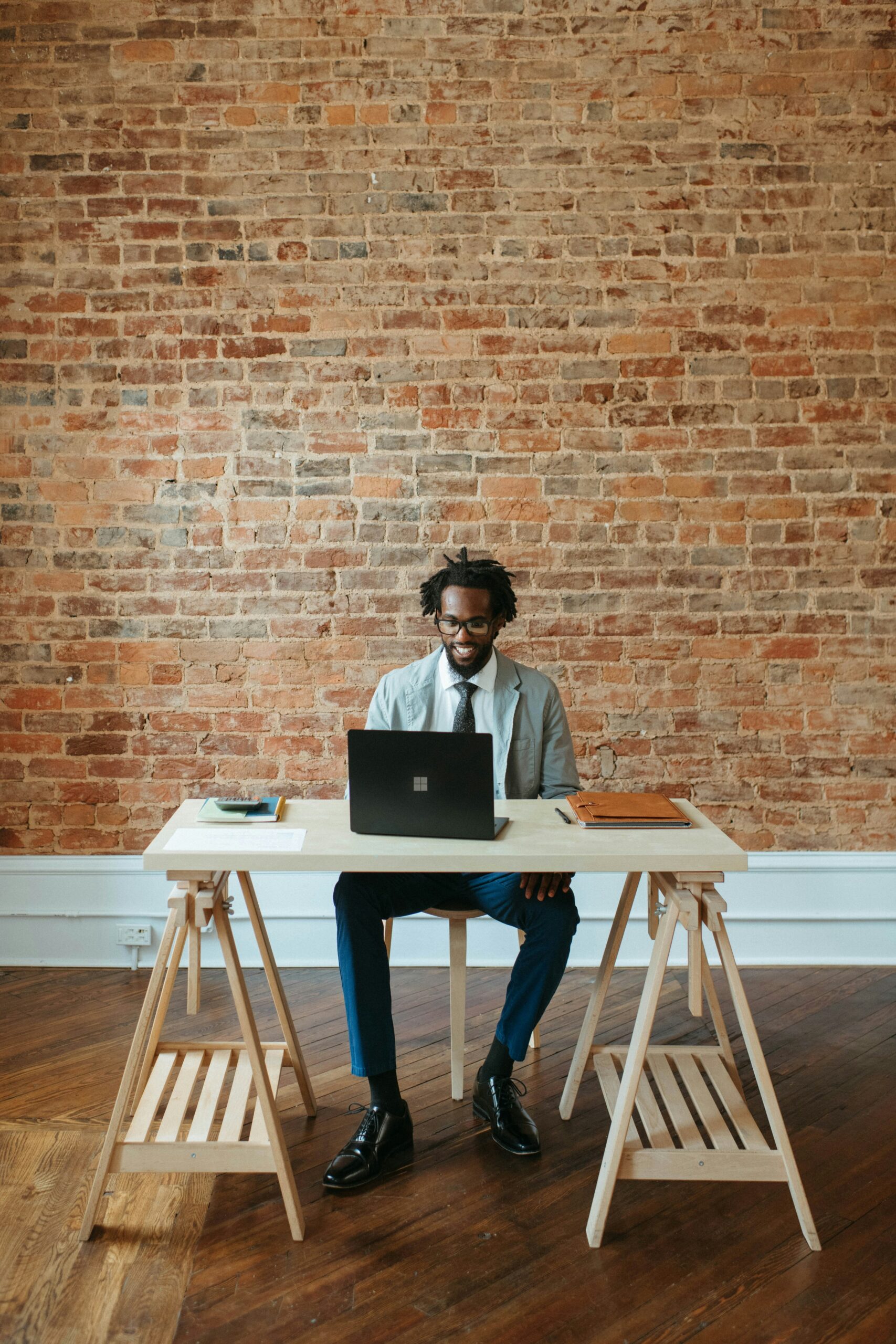 An employer working at a desk on a laptop, representing Florida employer requirements and fiduciary responsibilities for employee benefits.