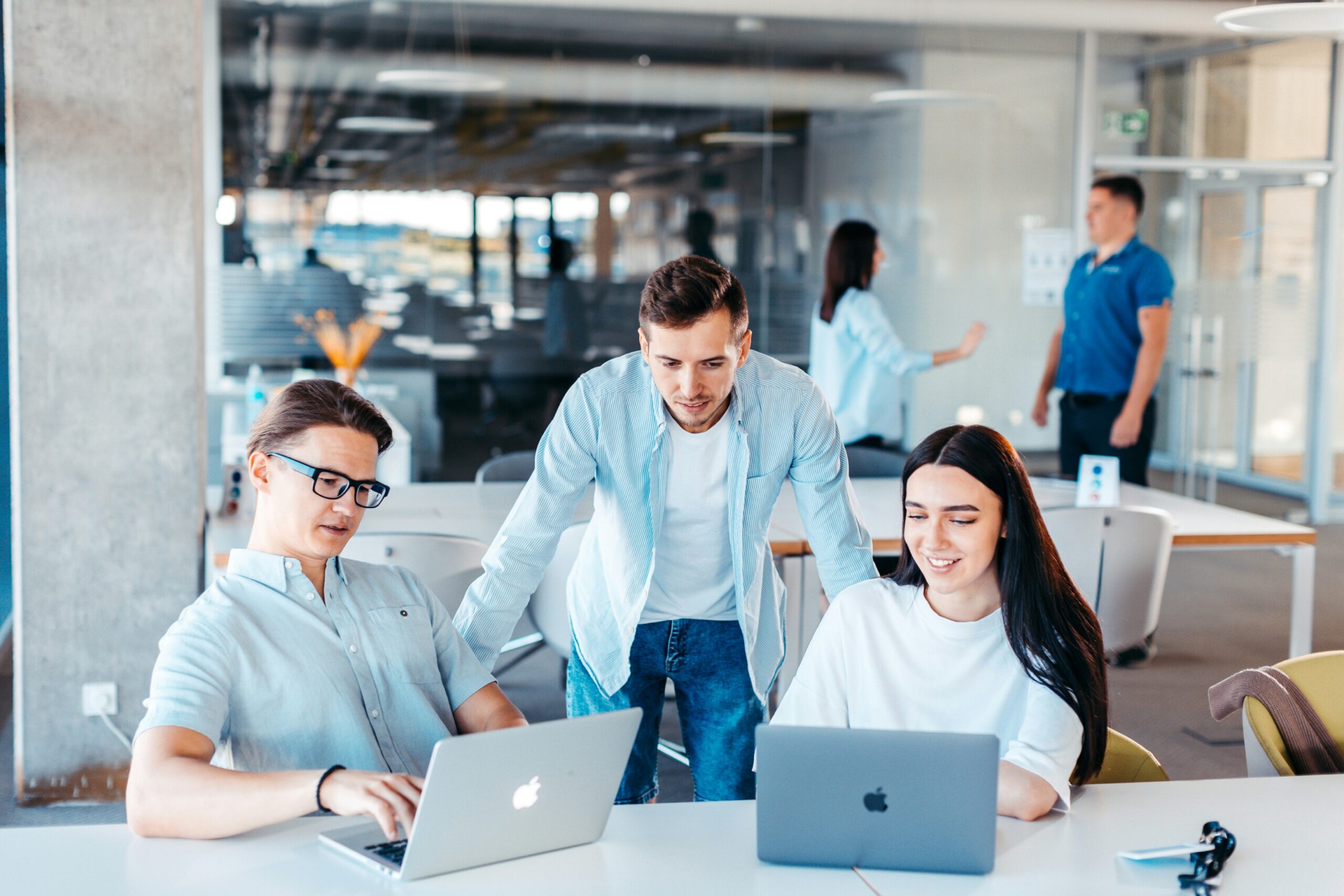 A team of employees reviewing information on laptops, representing how Florida small businesses compare group health insurance costs and benefits effectively.
