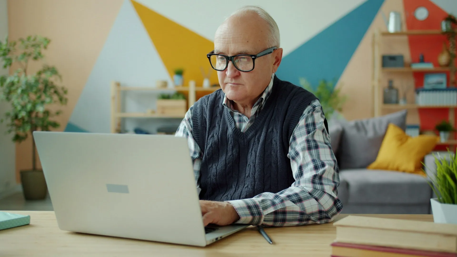 Senior man using laptop at home, focusing on Medicare plan options and healthcare decision-making.