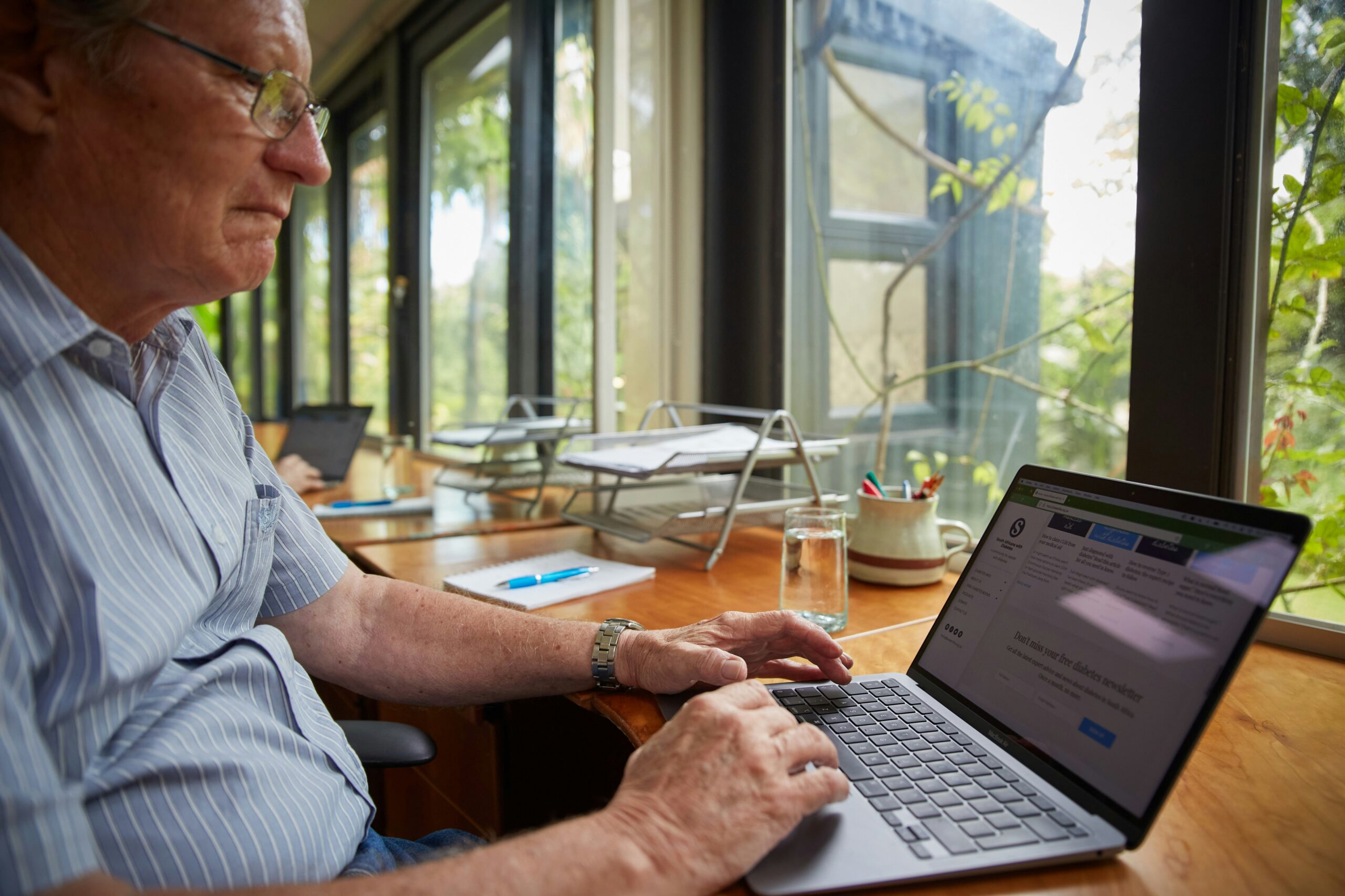 A Florida senior using a laptop to review Medicare assistance programs and cost-saving strategies to help lower healthcare expenses.