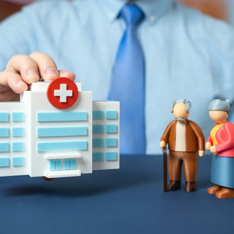 Illustration of a hospital model and senior couple representing key health insurance insights and coverage options for seniors in Florida.