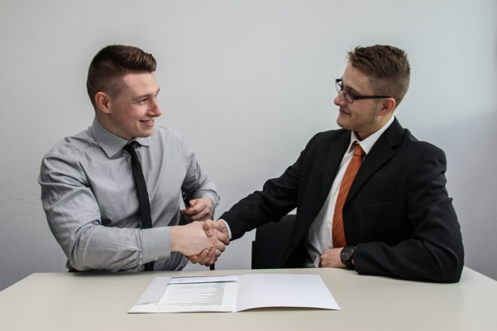 A business professional shake hands after agreeing on employer-sponsored health coverage that supports employee benefits and retention.