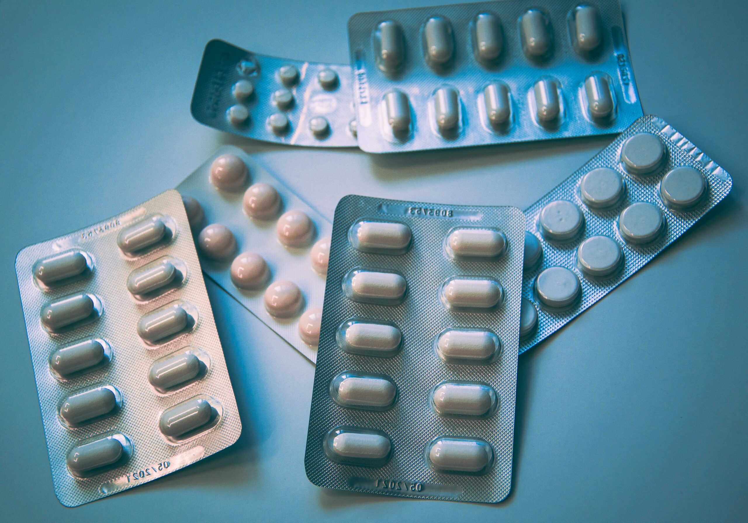 Medicines placed on blue surface | ProCare Consulting Prescription medication bottles on a table to represent Part D drug coverage