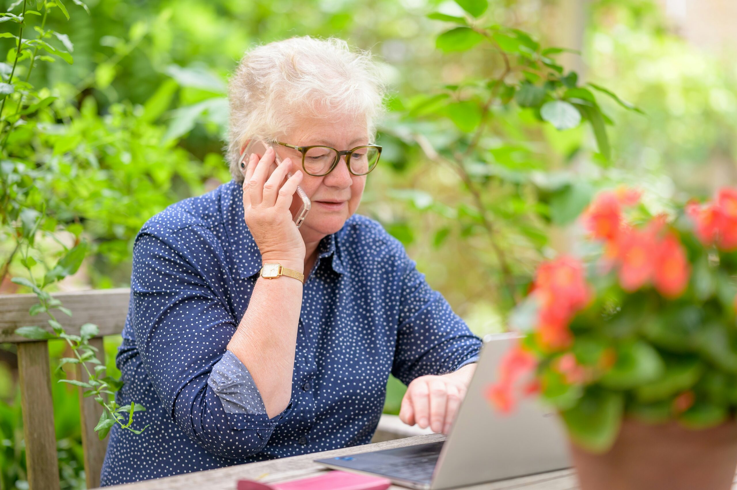 Senior woman comparing Medicare Supplement plans while speaking on the phone.
