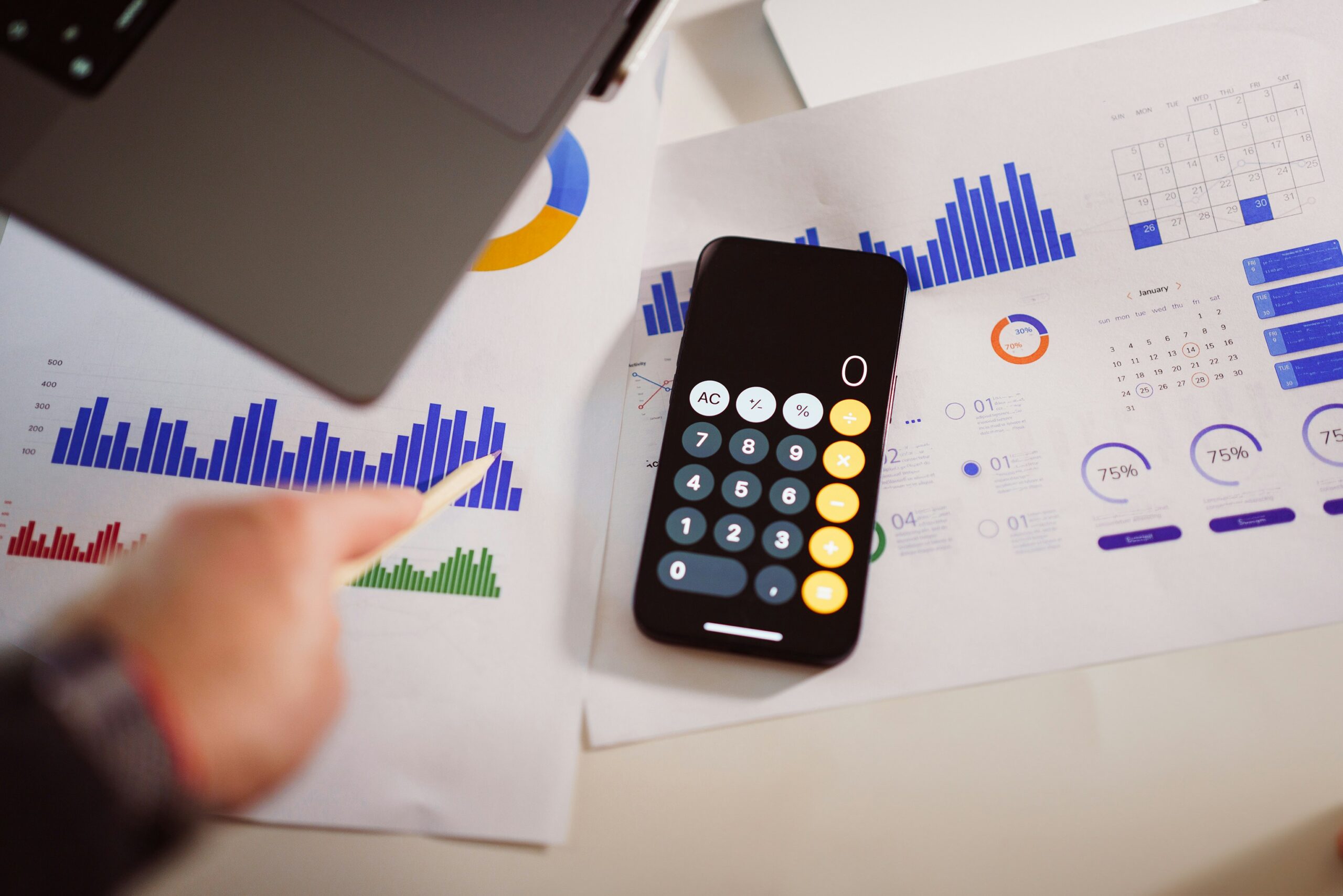 A calculator, laptop and graph