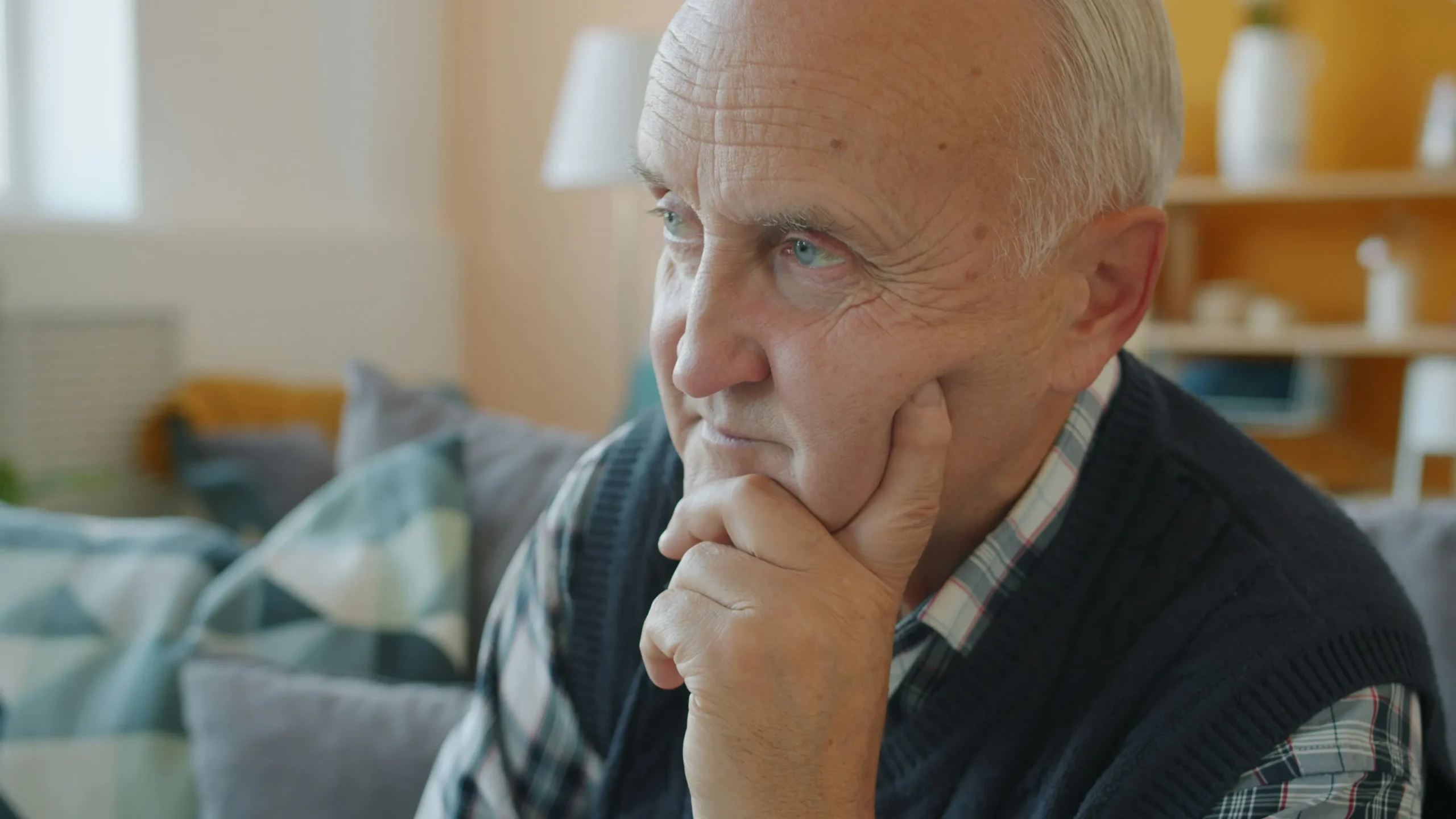 Older man sitting thoughtfully at home