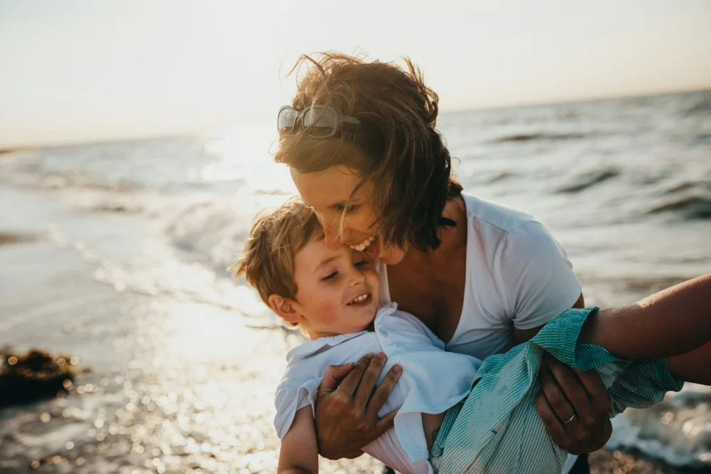 Parent holding a young child at the beach