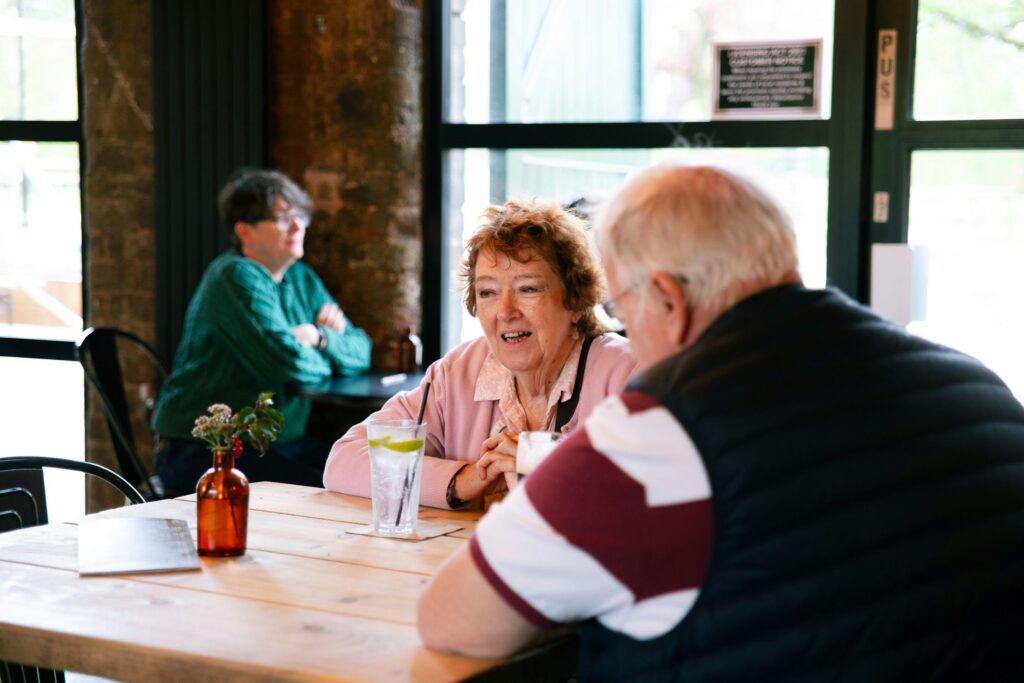 Two couples talking at a table in a cafe